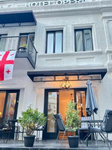 a building with chairs and an umbrella in front of it at Opera City Center Hotel in Tbilisi City +11 photos