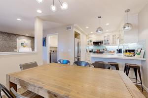 a dining room and kitchen with a wooden table and chairs at Castles Reach in Anaheim +20 photos