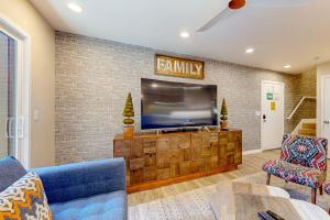 a living room with a flat screen tv on a brick wall at Castles Reach in Anaheim