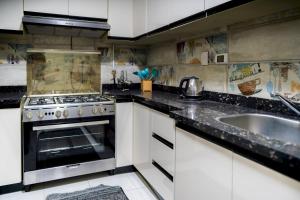 a kitchen with a stove and a sink at 903 . Spacious 3BR Apt. 2 Baths Gated Community in Sheikh Zayed