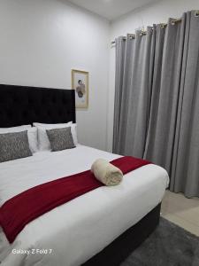 a bedroom with a large bed with a red blanket at 32 on Magasa in Blantyre