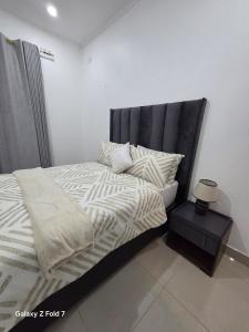 a bed with a black headboard in a bedroom at 32 on Magasa in Blantyre +3 photos