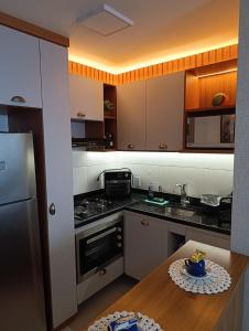 a kitchen with a stove and a table in it at nityloft com piscina e academia em Icaraí in Niterói