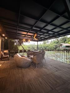 a patio with a table and chairs on a deck at Villas by Helanka in Gonawala