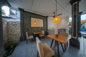 a dining room with two tables and chairs at Eva Guest House in Canggu