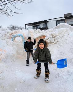 two young children are standing in the snow at Motel Bonsoir in Joliette