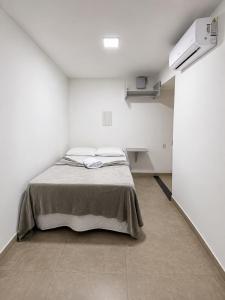 a bedroom with a bed in a white room at Manaira Suite 01 in João Pessoa