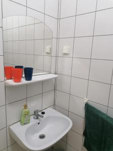 a white bathroom with a sink and a mirror at Luna Vendégház in Ipolyvece +29 photos