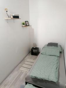 a bedroom with a bed with a green blanket at Luna Vendégház in Ipolyvece