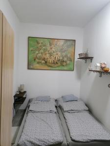 a room with three beds and a painting on the wall at Luna Vendégház in Ipolyvece