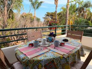 a table with a tea set on a balcony at Casa vacanze SALSEDINE in Mascali