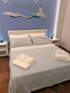 a bedroom with a bed with two towels on it at Casa vacanze SALSEDINE in Mascali