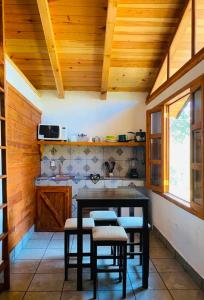 a kitchen with a table and stools in a room at Cabañas las Alazanas in Mazamitla