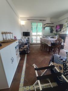 a kitchen and living room with a table and chairs at Casa vacanze SALSEDINE in Mascali