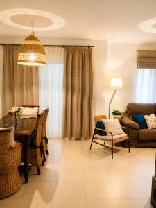 a living room with a table and a couch at Casa familiar con patio privado y piscina comunitaria cerca de la playa in Málaga
