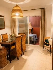a dining room with a table and chairs at Casa familiar con patio privado y piscina comunitaria cerca de la playa in Málaga