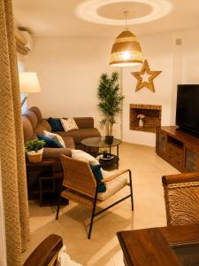 a living room with a couch and a table at Casa familiar con patio privado y piscina comunitaria cerca de la playa in Málaga