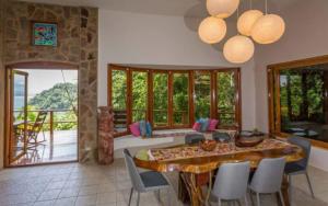a living room with a table and chairs and a balcony at Casa Pura Paz in Puntarenas