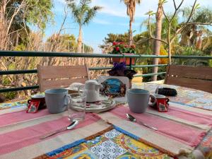 a table with a table cloth and cups and utensils at Casa vacanze SALSEDINE in Mascali