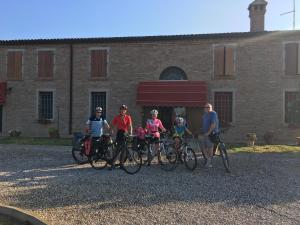 a group of people standing with their bikes in front of a building at Il Frattiero B&B in Voghenza