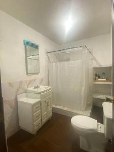 a white bathroom with a toilet and a sink at Los Aposentos Antigua in Antigua Guatemala