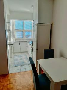 a kitchen with a table and chairs and a refrigerator at Apartman Centar, Modrica in Modriča