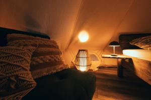 a bedroom with a bed and a lamp in it at Zálesie Glamping in Kostolná Ves