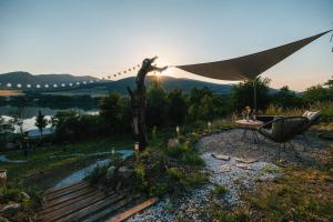a patio with a table and a chair and an umbrella at Zálesie Glamping in Kostolná Ves