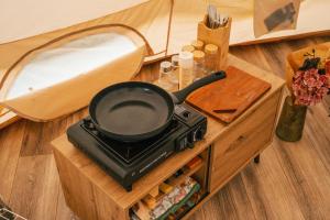a frying pan on a stove in a tent at Zálesie Glamping in Kostolná Ves