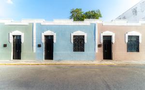 a building with black doors on the side of a street at Casa Balada Santa Lucía with Parking by Cercana in Mérida