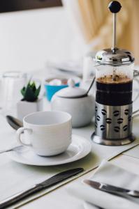 una mesa con una taza de café y una licuadora en Admirals Lodge Guest House, en Port Elizabeth