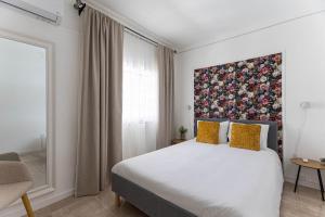 a bedroom with a bed with a painting on the wall at Quinta dos Canais in Setúbal +29 photos
