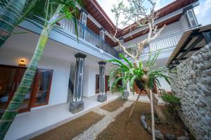 a courtyard of a house with palm trees at Eva Guest House in Canggu
