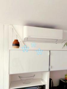 a white cabinet with blue flowers on it at Petit Biscuit - Wi-Fi - Kitchen - AC - Parking in Lido di Camaiore