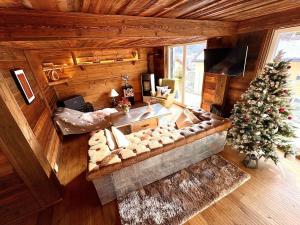 a living room with a couch and a christmas tree at Alpine Chic Escape with Spa & Panoramic Views in Engelberg