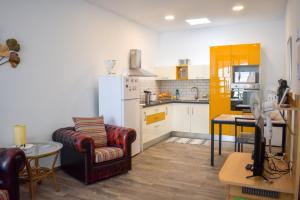 a kitchen with a refrigerator and a couch and a table at Casa El Nido, Agaete in Agaete
