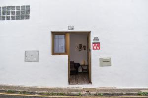 a white building with a door with a table in it at Casa El Nido, Agaete in Agaete