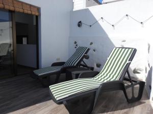three green and white chairs sitting next to a wall at Casa El Nido, Agaete in Agaete +5 photos