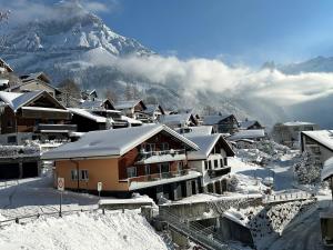 a snow covered village with a mountain in the background at Alpine Chic Escape with Spa & Panoramic Views in Engelberg