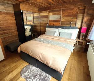 a bedroom with a bed in a room with wooden walls at Alpine Chic Escape with Spa & Panoramic Views in Engelberg