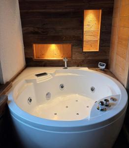 a large white tub in a bathroom with wooden walls at Alpine Chic Escape with Spa & Panoramic Views in Engelberg +23 photos