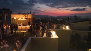 a group of people standing on a rooftop at night at Jata Hotel in Tirana
