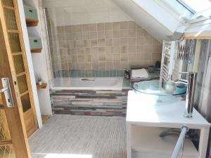 a bathroom with a tub and a sink at Ty Palms - Maison d'hôtes in Plomodiern +68 photos