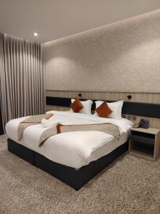 a bedroom with a large bed with white sheets and orange pillows at فندق لوشال LECHAL Hotel in Medina +83 photos