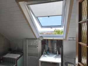 a skylight window in a bathroom with a sink at Ty Palms - Maison d'hôtes in Plomodiern