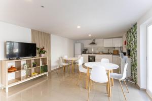 a kitchen and dining room with white tables and chairs at Quinta dos Canais in Setúbal