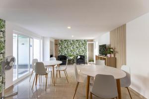 a dining room with white tables and white chairs at Quinta dos Canais in Setúbal