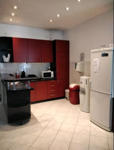 a kitchen with red cabinets and a white refrigerator at The Old Town Hostel-Villa Gradac in Dubrovnik