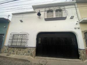 a white building with two gates and two windows at Los Aposentos Antigua in Antigua Guatemala