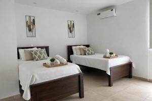 two beds in a room with white walls at Urbanización privada, seguridad y confort in Manta +43 photos